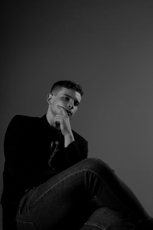 Free Black and white portrait of a thoughtful young man in a studio setting. Stock Photo