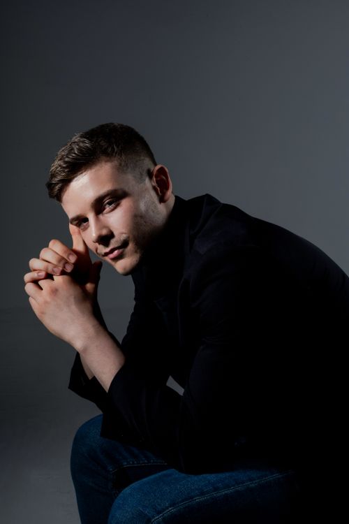 Free Portrait of a young man wearing dark clothes, thoughtfully posed. Stock Photo