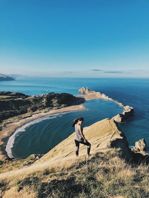 Woman Standing on Brown Mountain Peak