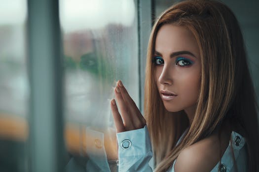 一位女性的时尚肖像，妆容引人注目，她凝视着玻璃窗，优雅与沉思被瞬间捕捉