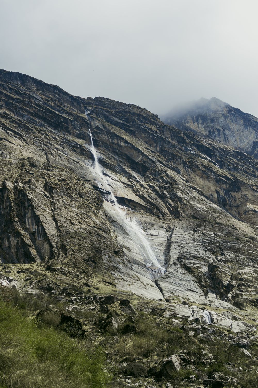 A waterfall is flowing down a mountain · Free Stock Photo