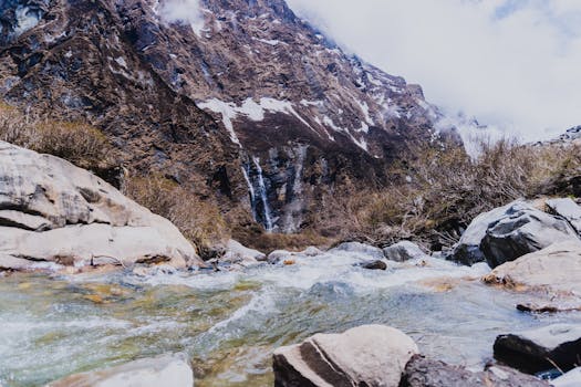 A picturesque stream flowing through the rugged landscape of the Himalayas in Ghandruk, Nepal.