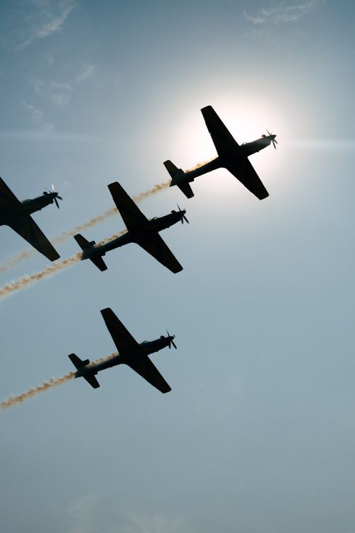 Free Silhouette of aerobatic planes flying in formation over Brazil with sun in the background. Stock Photo