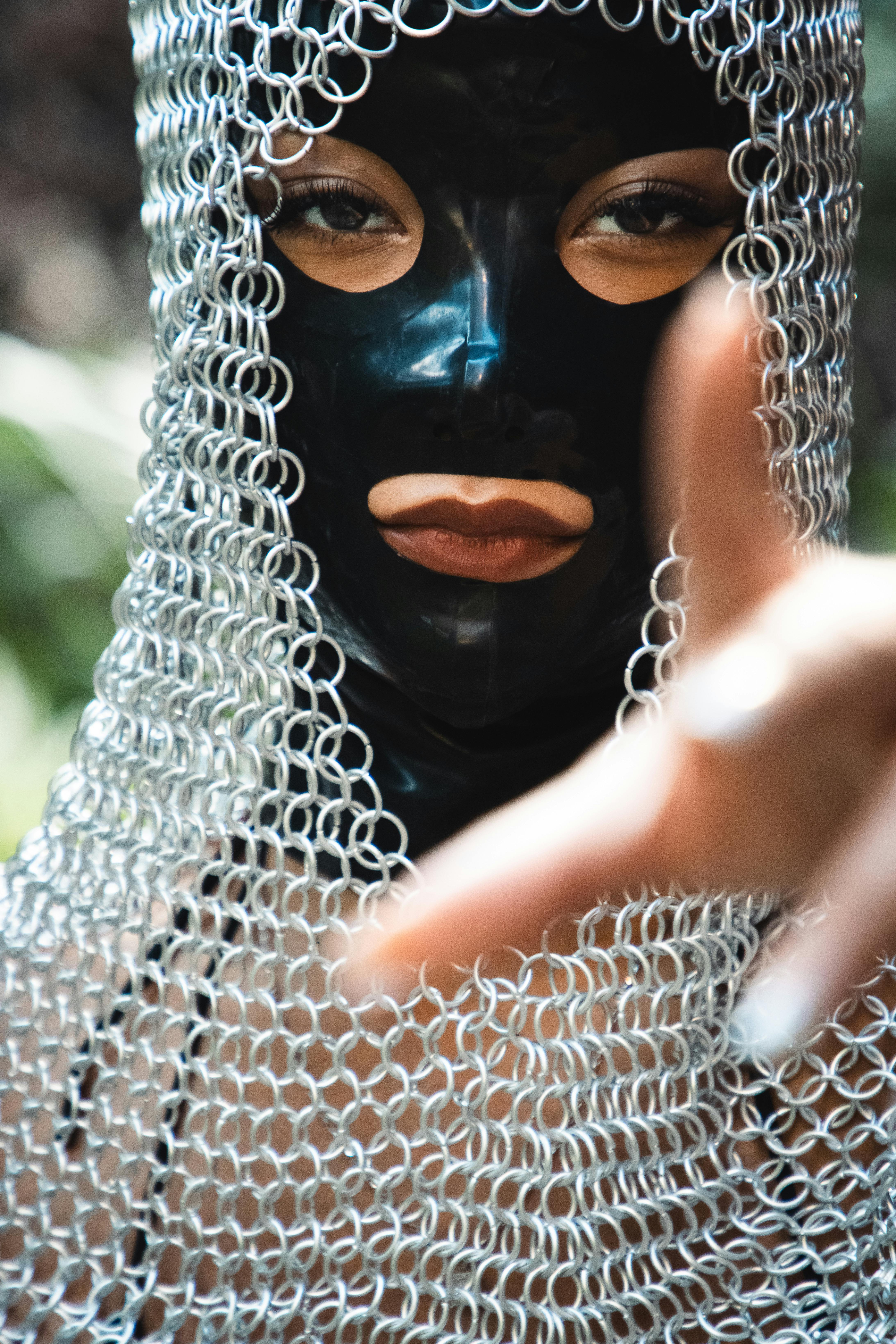 a woman wearing a chain mail mask and gloves
