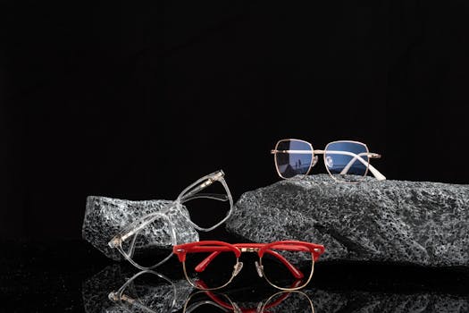 Elegant eyeglasses resting on textured rocks against a dark background, showcasing modern eyewear fashion.