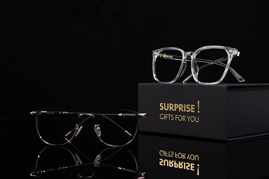Stylish eyeglasses on a luxury gift box with a black background, perfect for fashion and design themes.