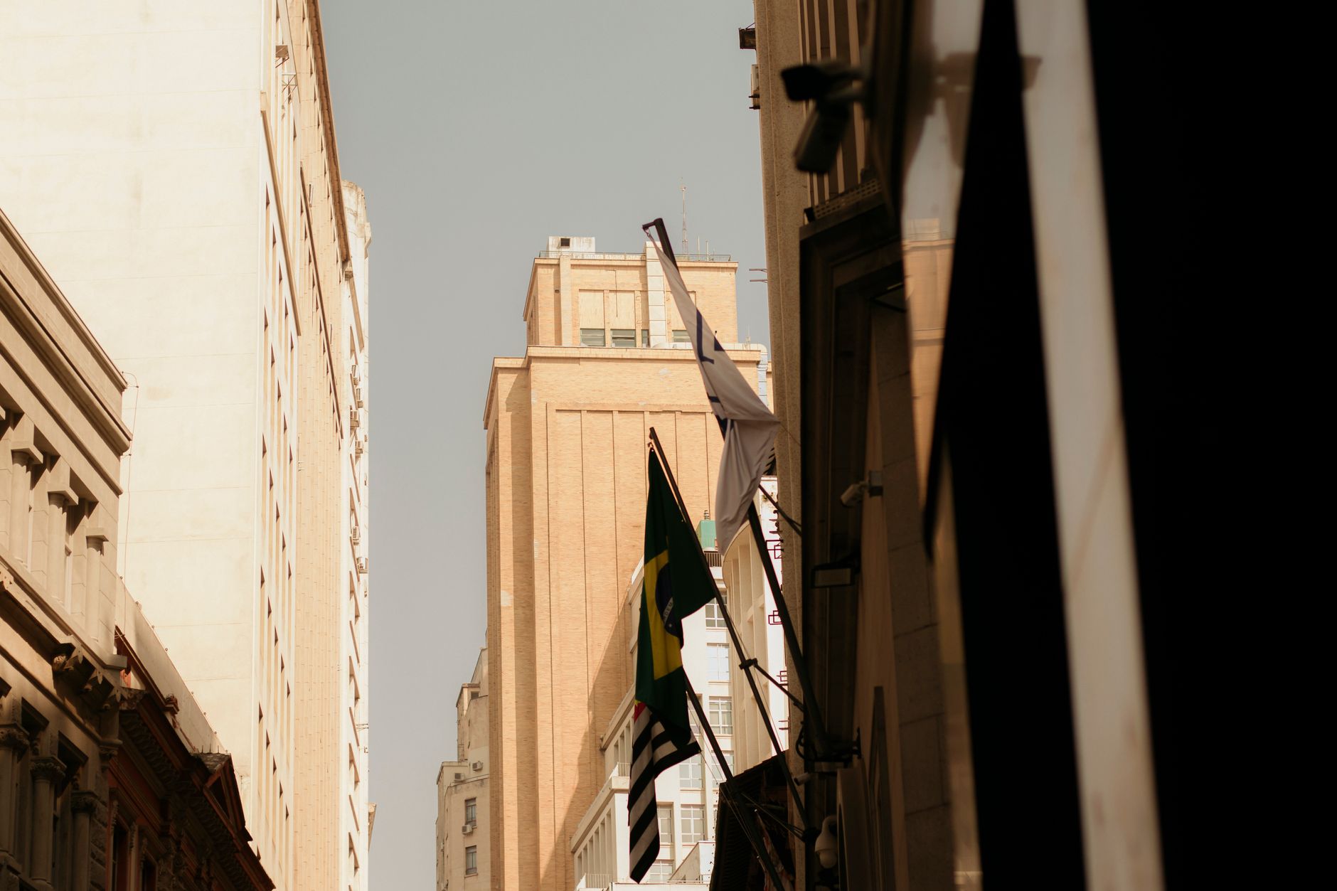 Urban scene featuring flags on buildings in a downtown area, showcasing modern architecture.