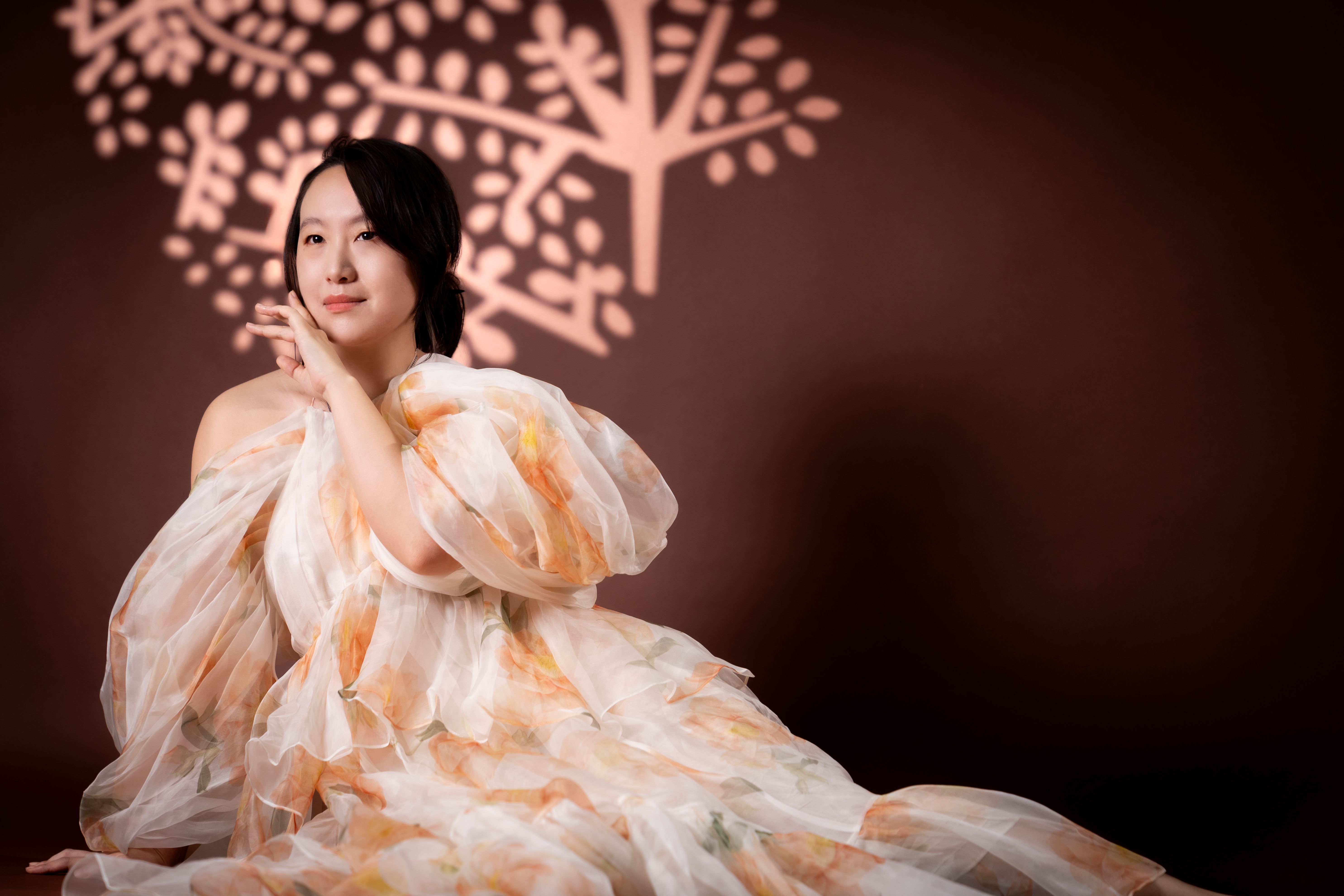 A woman in a floral dress sitting on the floor · Free Stock Photo