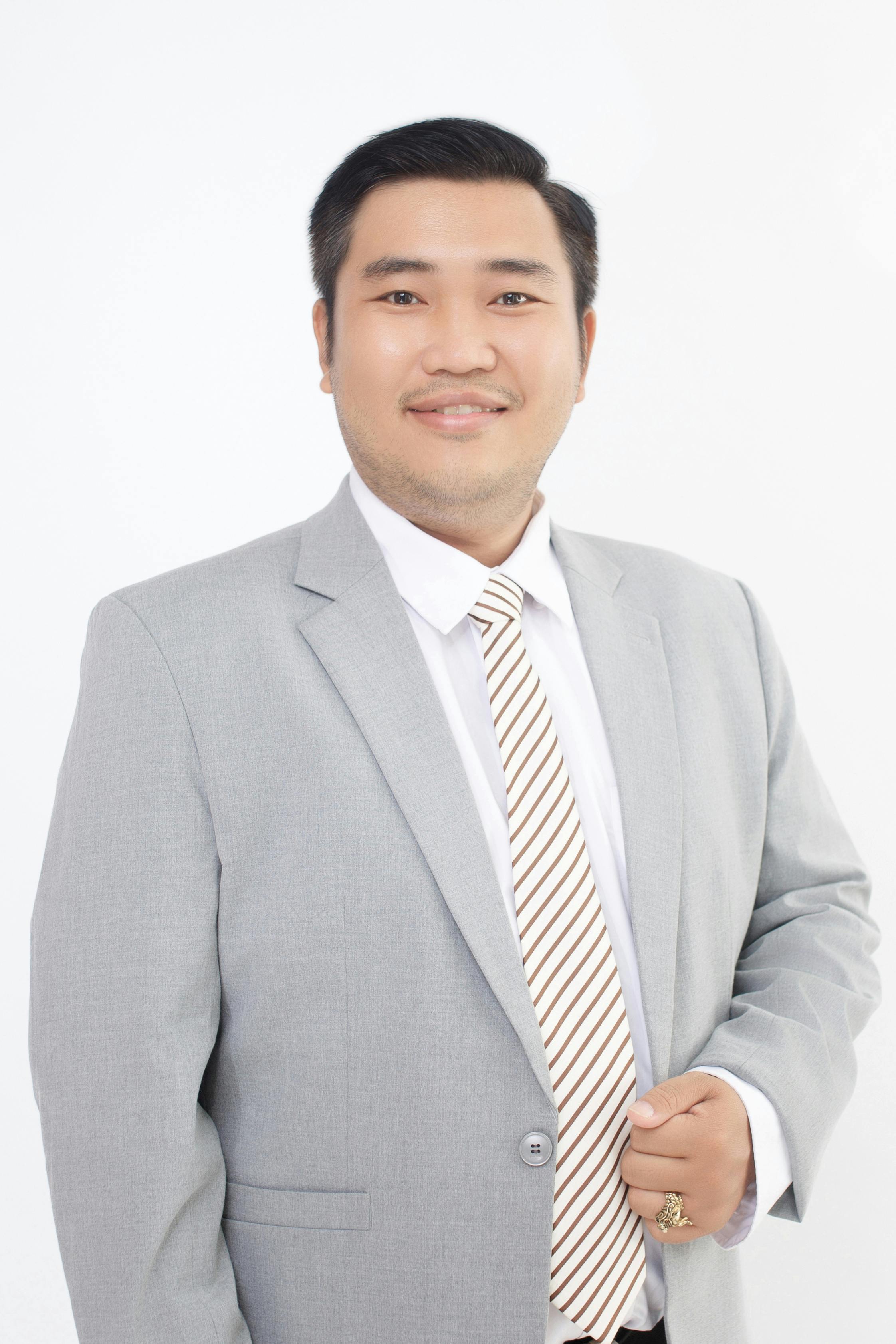 Portrait of a confident businessman wearing a grey suit and striped tie, exuding professionalism and success.