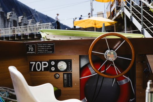 Close-up of a classic cruise boat steering wheel in Ghent, Belgium, with a vibrant outdoor setting.