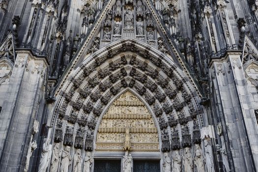 Detailed view of a Gothic cathedral's facade featuring intricate stone carvings and statues.