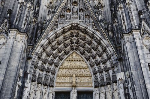Free Detailed view of a Gothic cathedral's facade featuring intricate stone carvings and statues. Stock Photo
