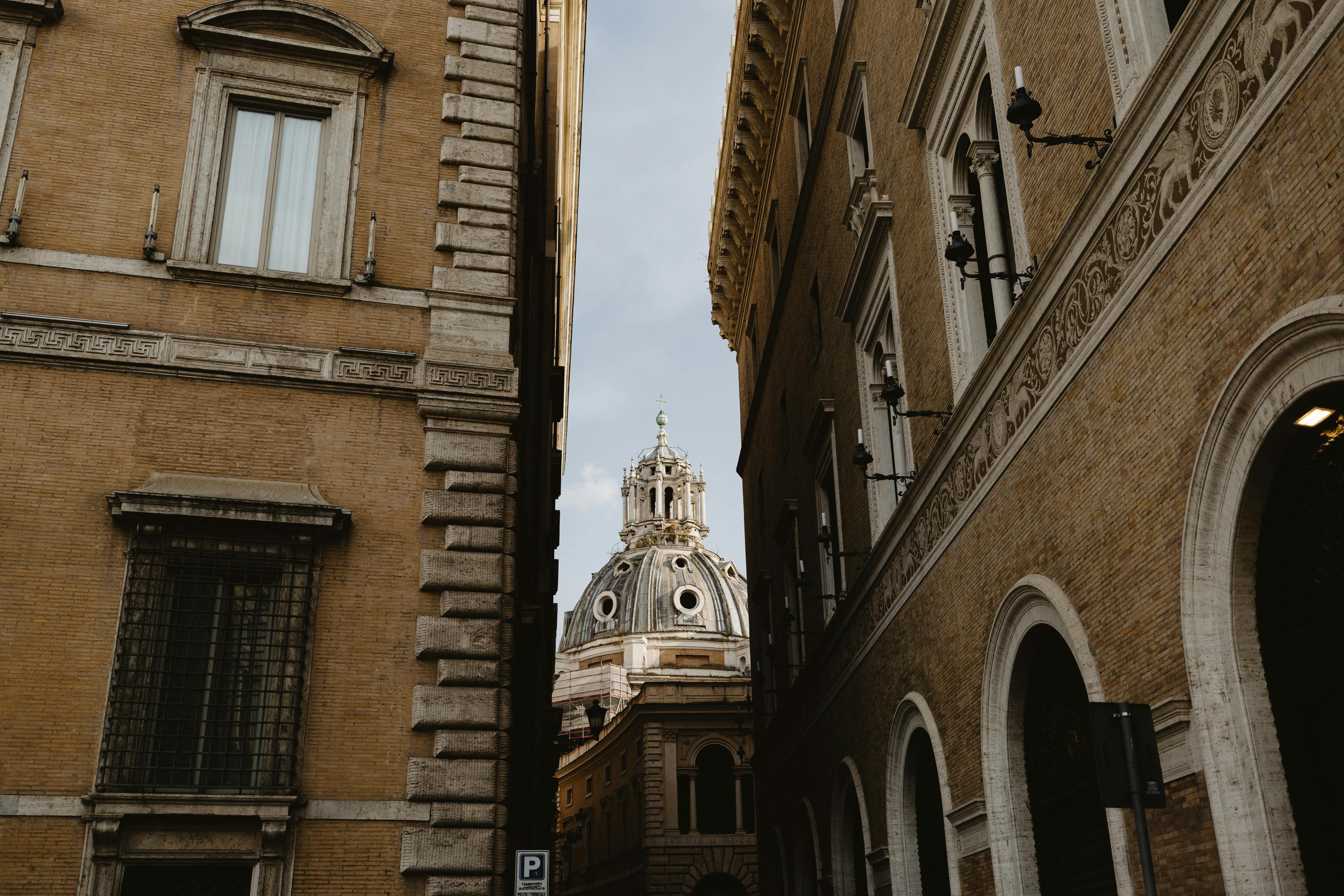 A captivating view of Vatican City's historic architecture leading towards a domed cathedral.