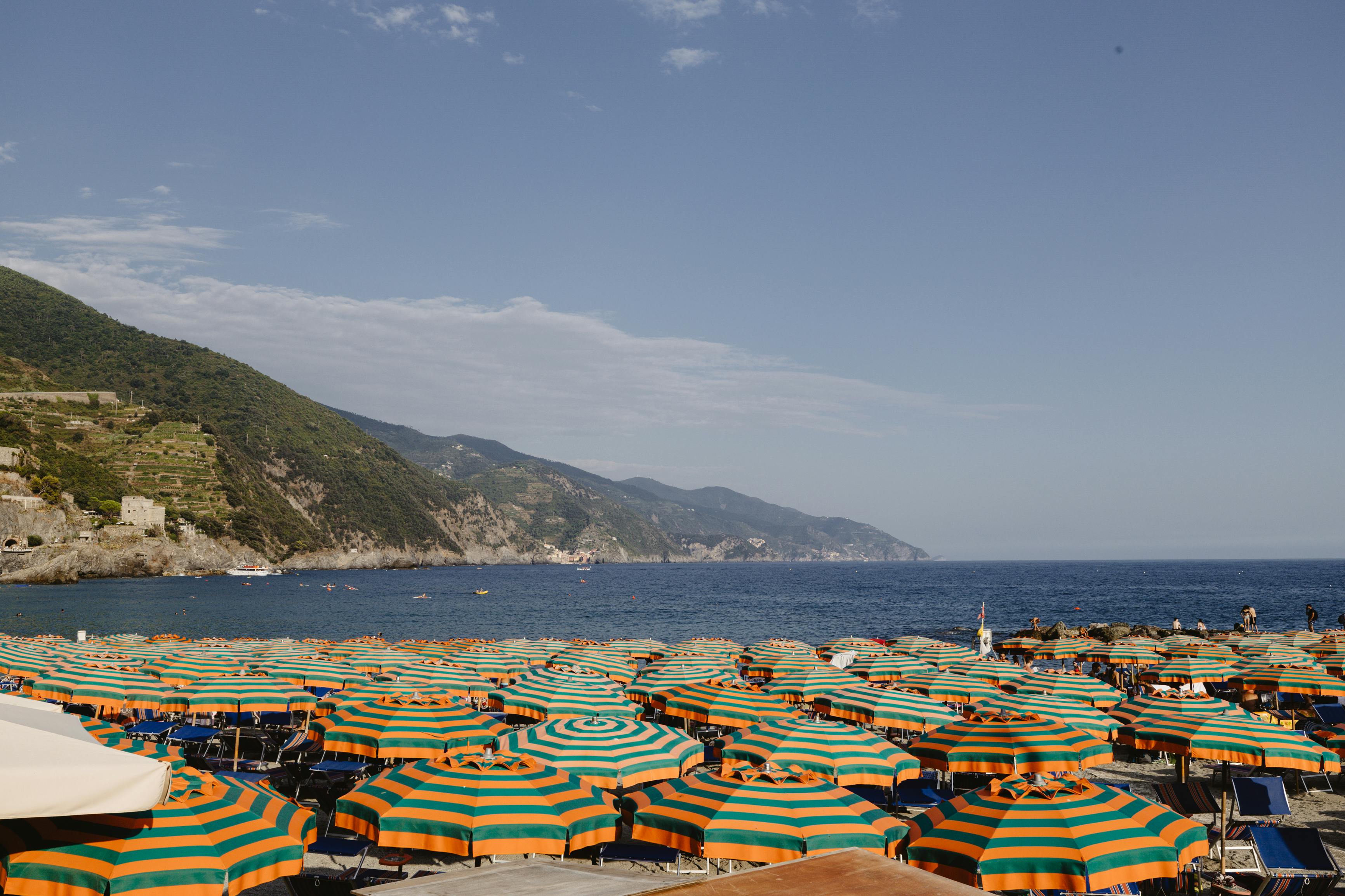 Vibrant beach umbrellas line the Ligurian coast, offering a stunning seaside view.