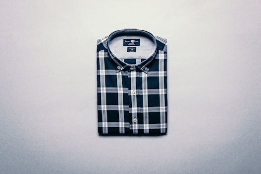 Neatly folded plaid shirt displayed on a flat gray surface, top view.