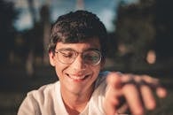 Selective Focus Photography of Smiling Man Wearing Black Framed Eyeglasses