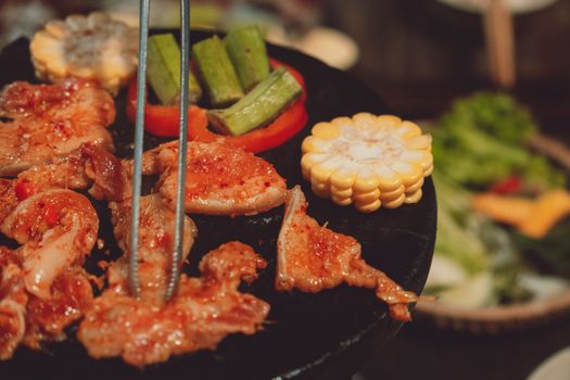 Delicious grilled meat and vegetables sizzling on a hot plate in Dalat, Vietnam.