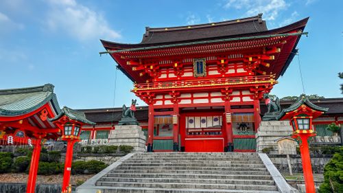 Free Vibrant red torii gate at Fushimi Inari Taisha Shrine, Kyoto, Japan, under a clear blue sky. Stock Photo
