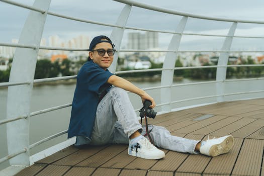 Casual portrait of a young man sitting on a bridge in Ho Chi Minh City, Vietnam.