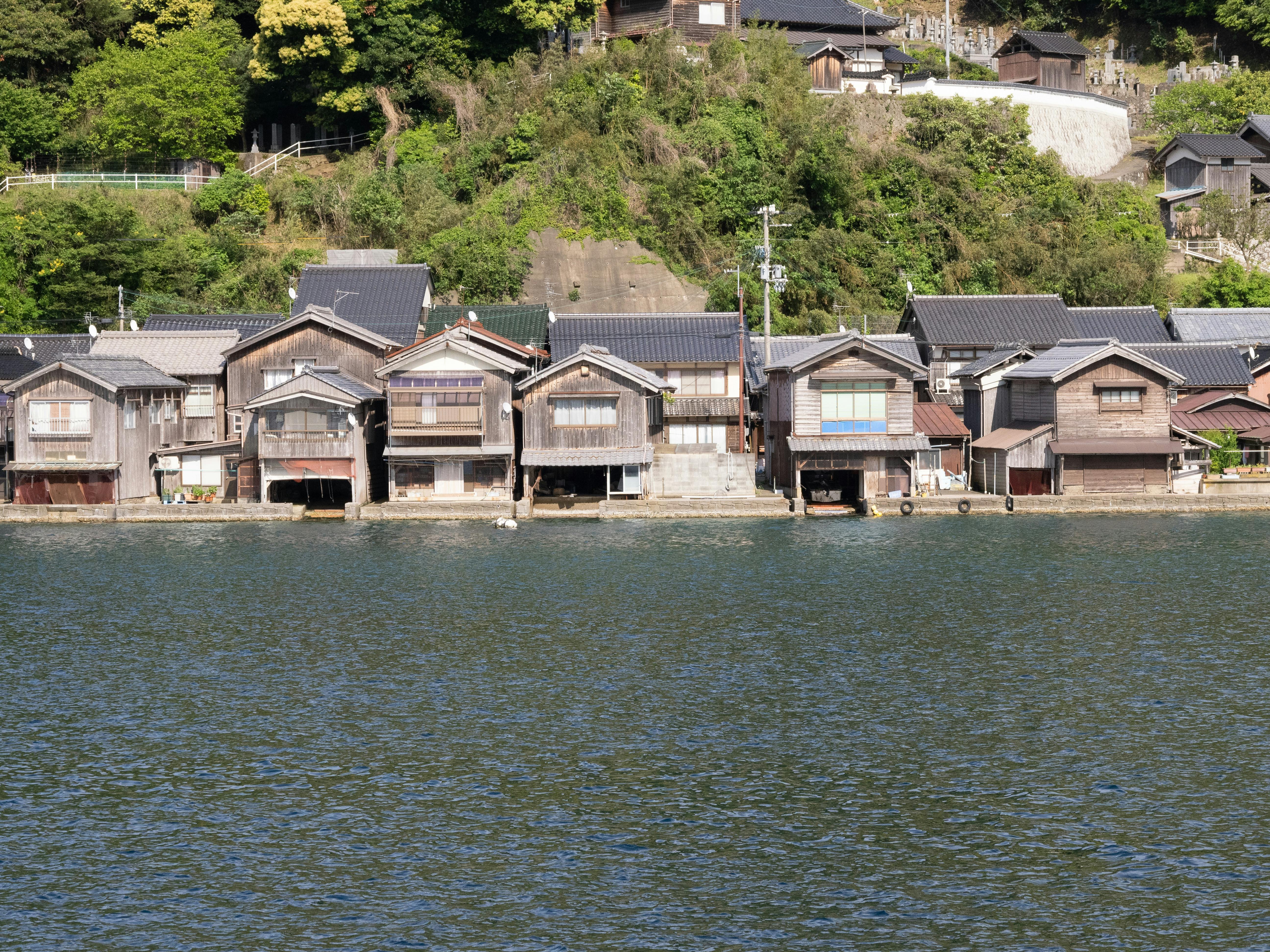 Traditional wooden houses by the water in Ine, Japan create a picturesque scene.