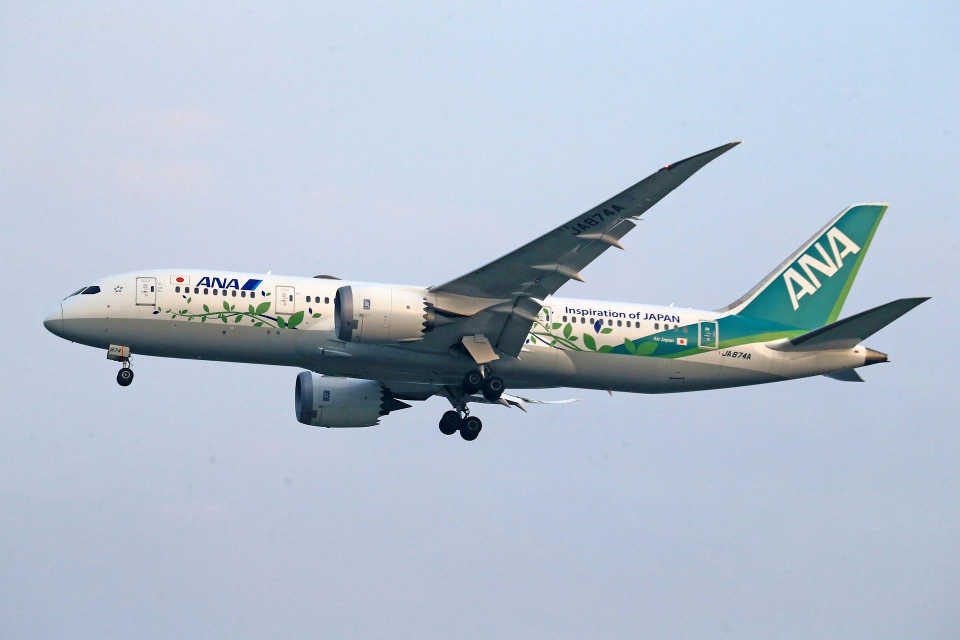 ANA aircraft featuring eco-friendly design in flight, side view.