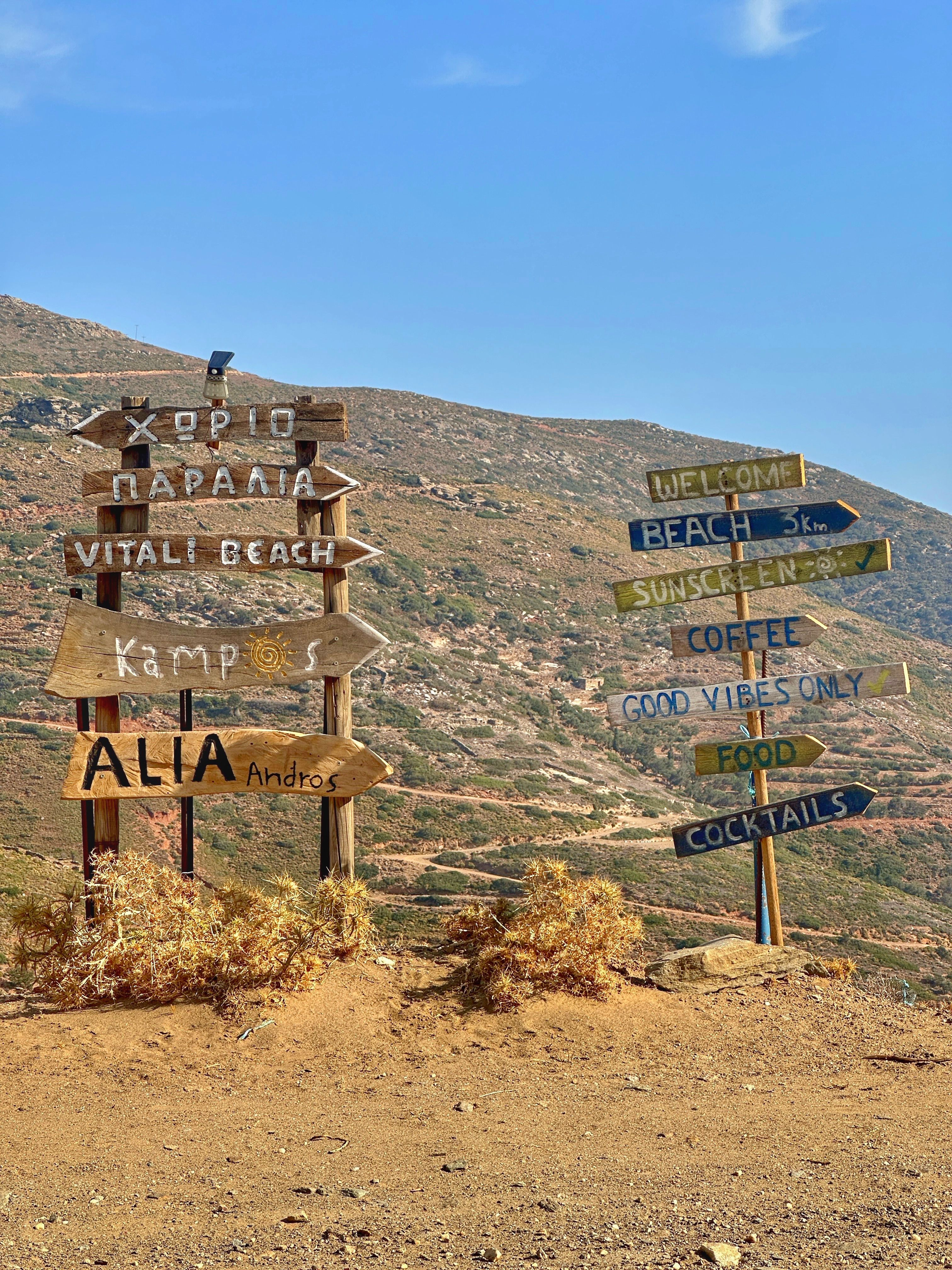 Wooden signs point to Vitani Beach and local spots on Andros Island.