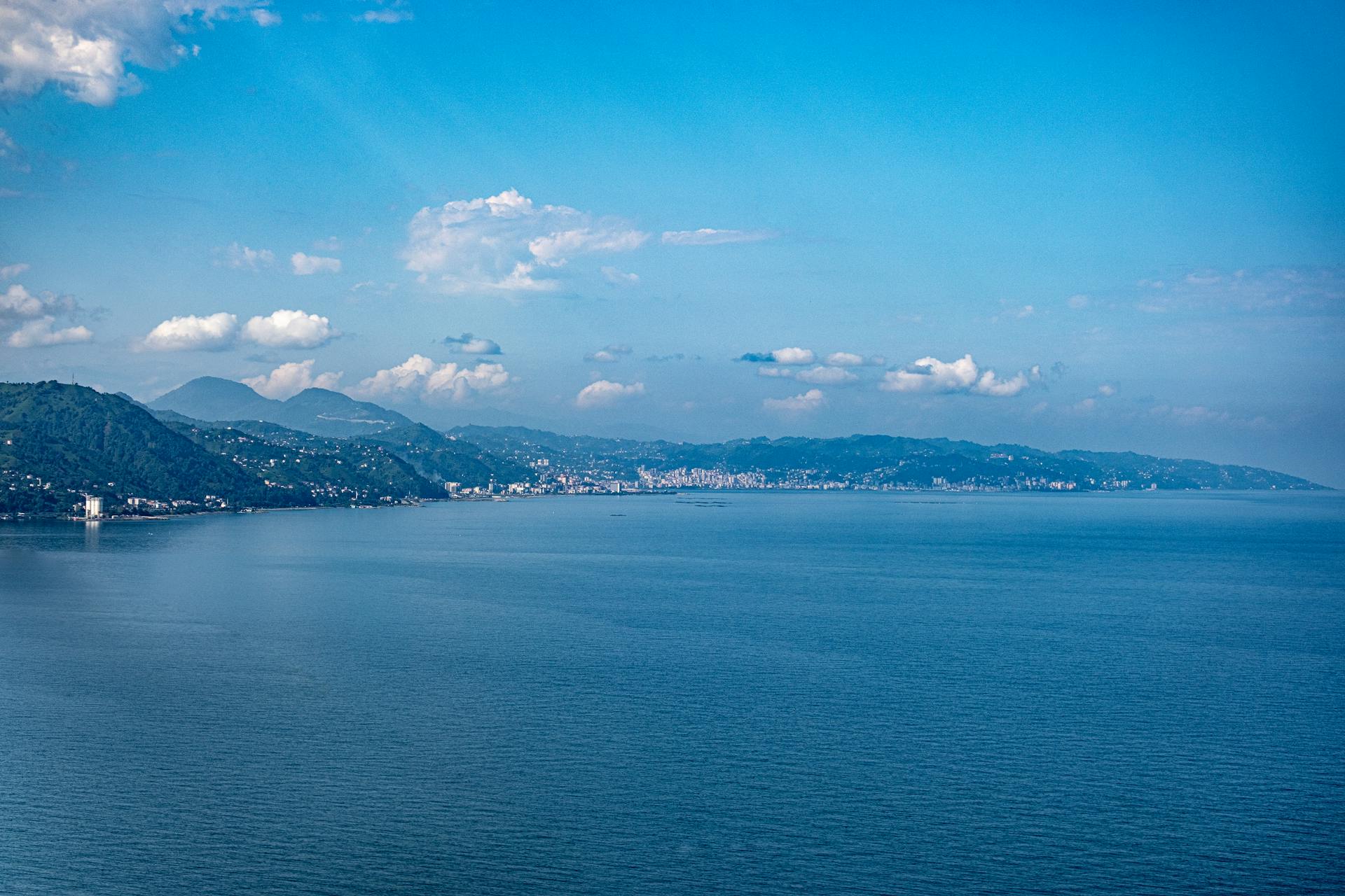 A breathtaking view of a coastal landscape with mountains and clear blue sea.