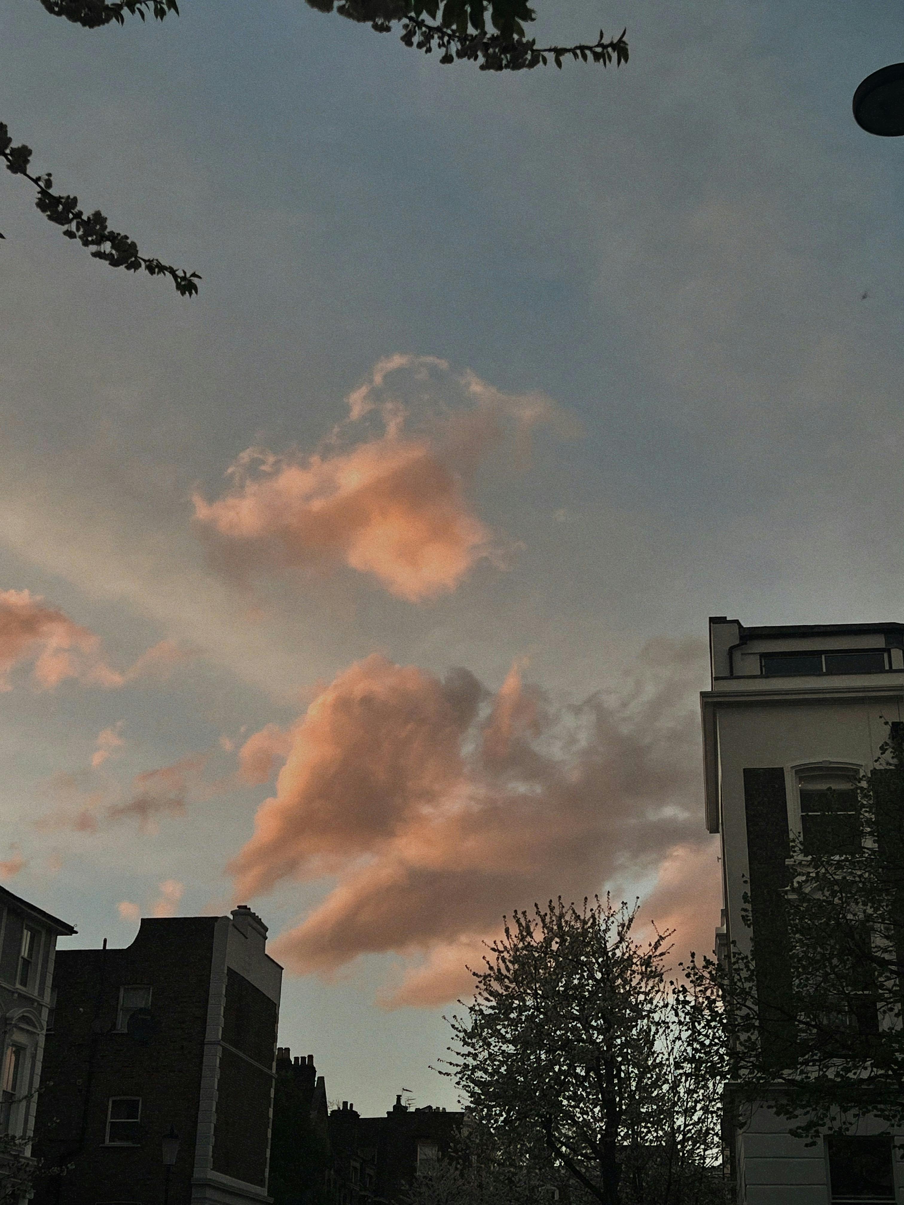 a pink cloud is seen in the sky above buildings