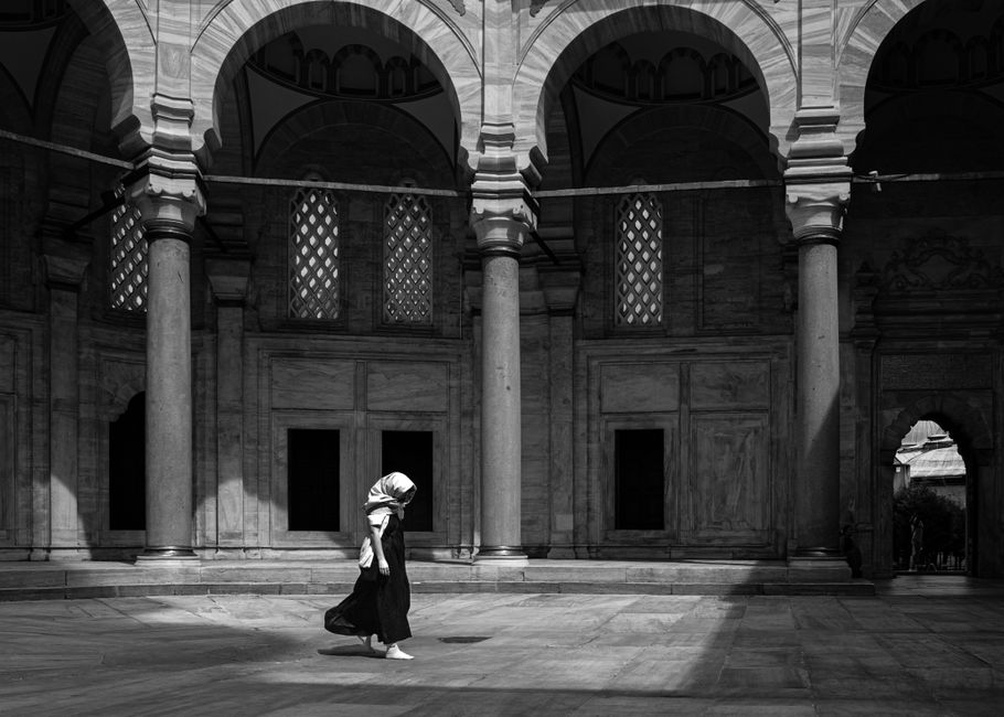 A lone figure walks in an architectural courtyard in Istanbul.