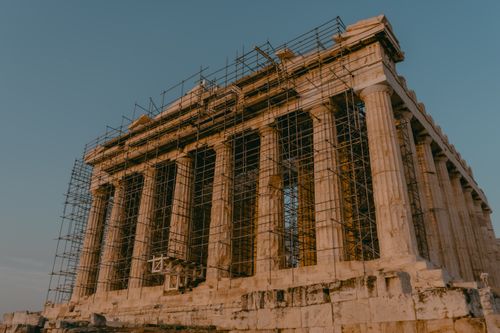 Free The Parthenon in Athens with scaffolding, capturing its majestic restoration during sunset. Stock Photo