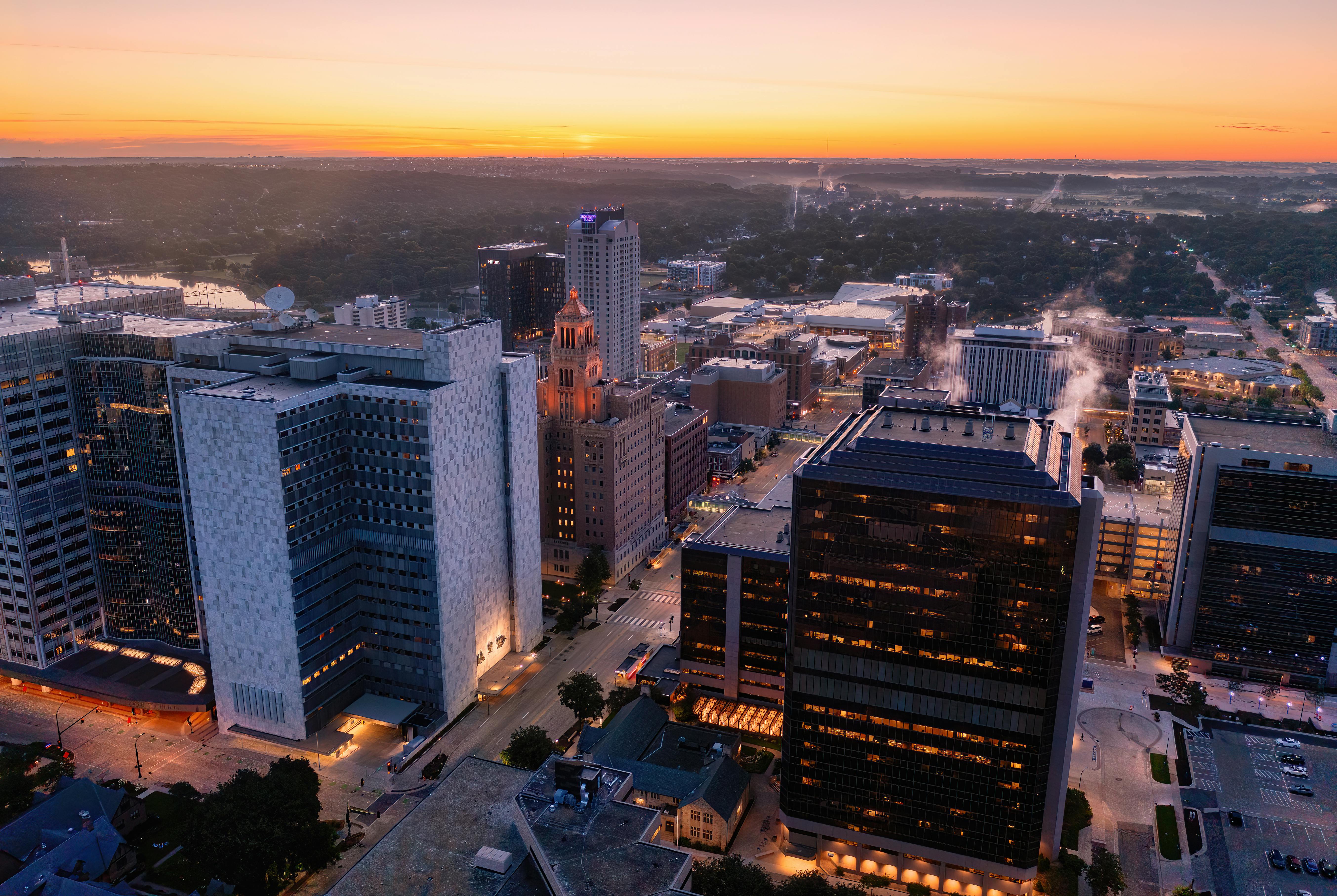 Aerial view of Rochester, MN skyline at sunset highlighting modern architecture and city lights.