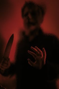 A shadowy figure with a knife behind distorted glass, exuding a cinematic horror vibe.