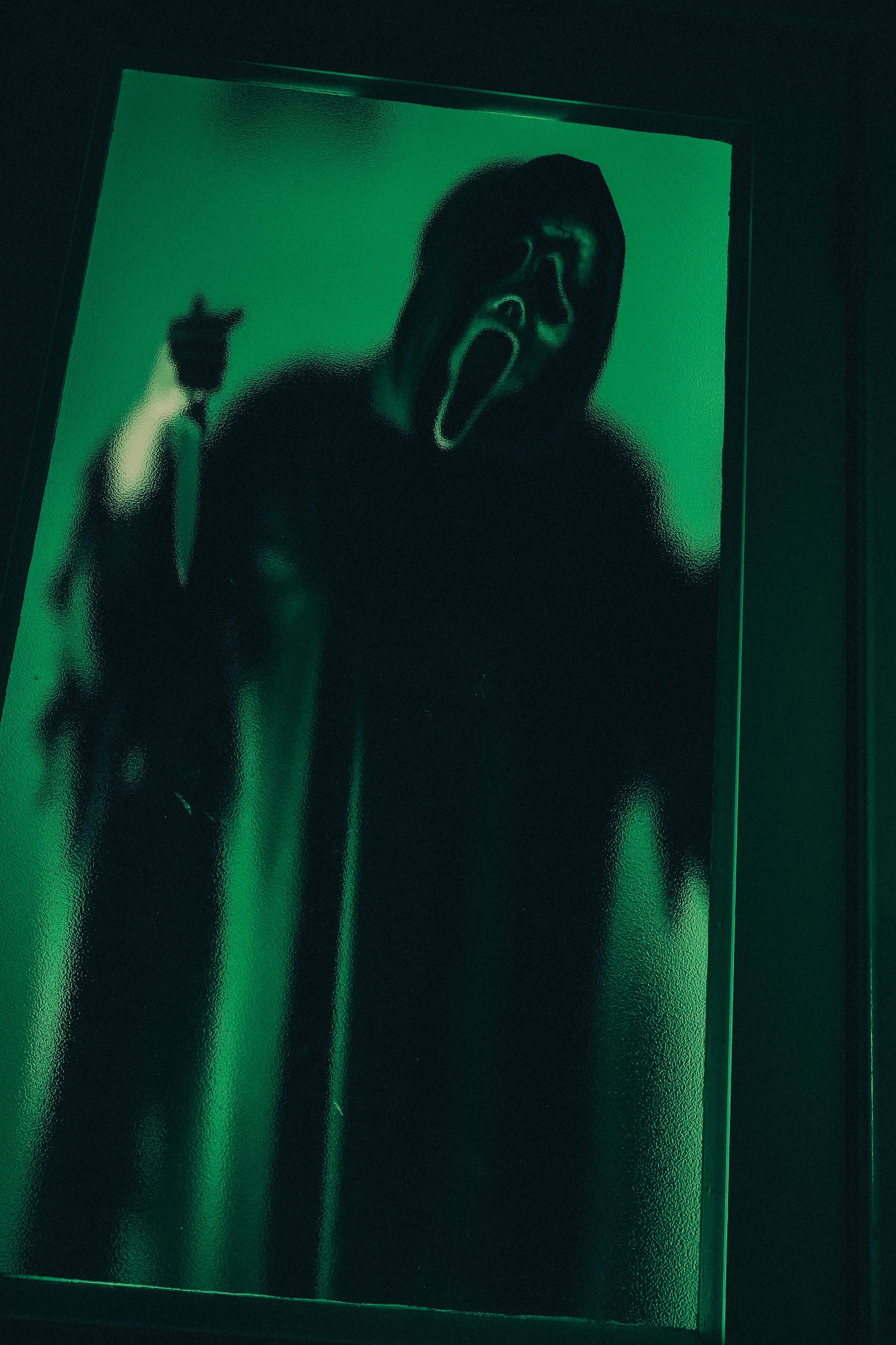 Eerie ghostly figure in a dark green-lit scene, reminiscent of horror films.