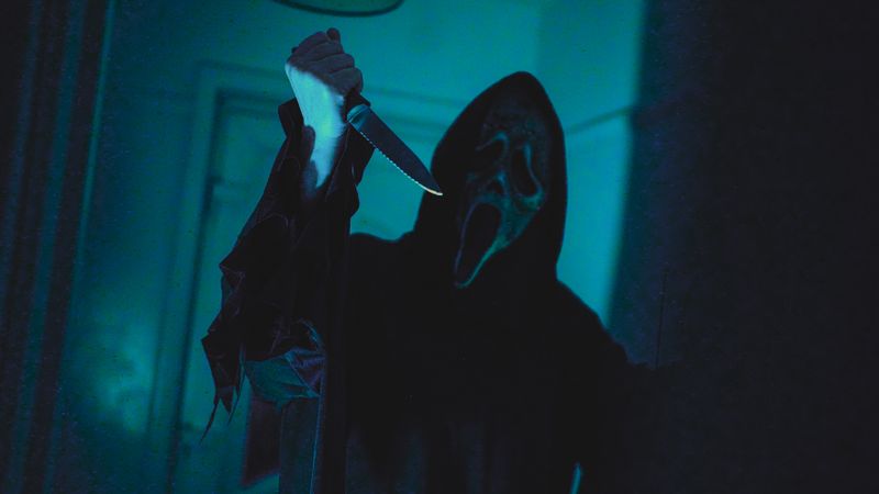 Dark, eerie scene with a masked figure holding a knife, evoking horror film vibes.