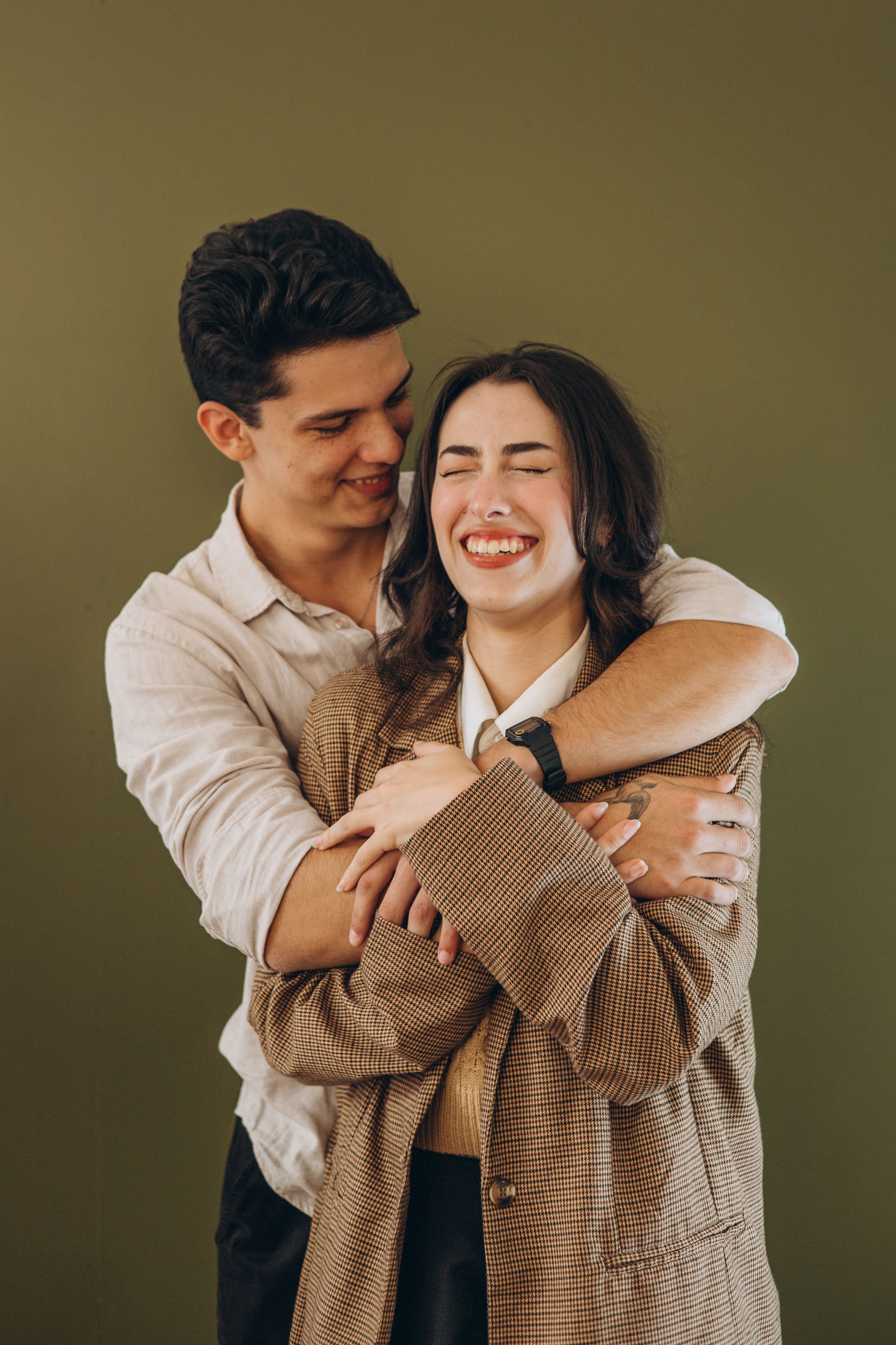 Joyful couple embracing with love in a studio setting, expressing affection and happiness.