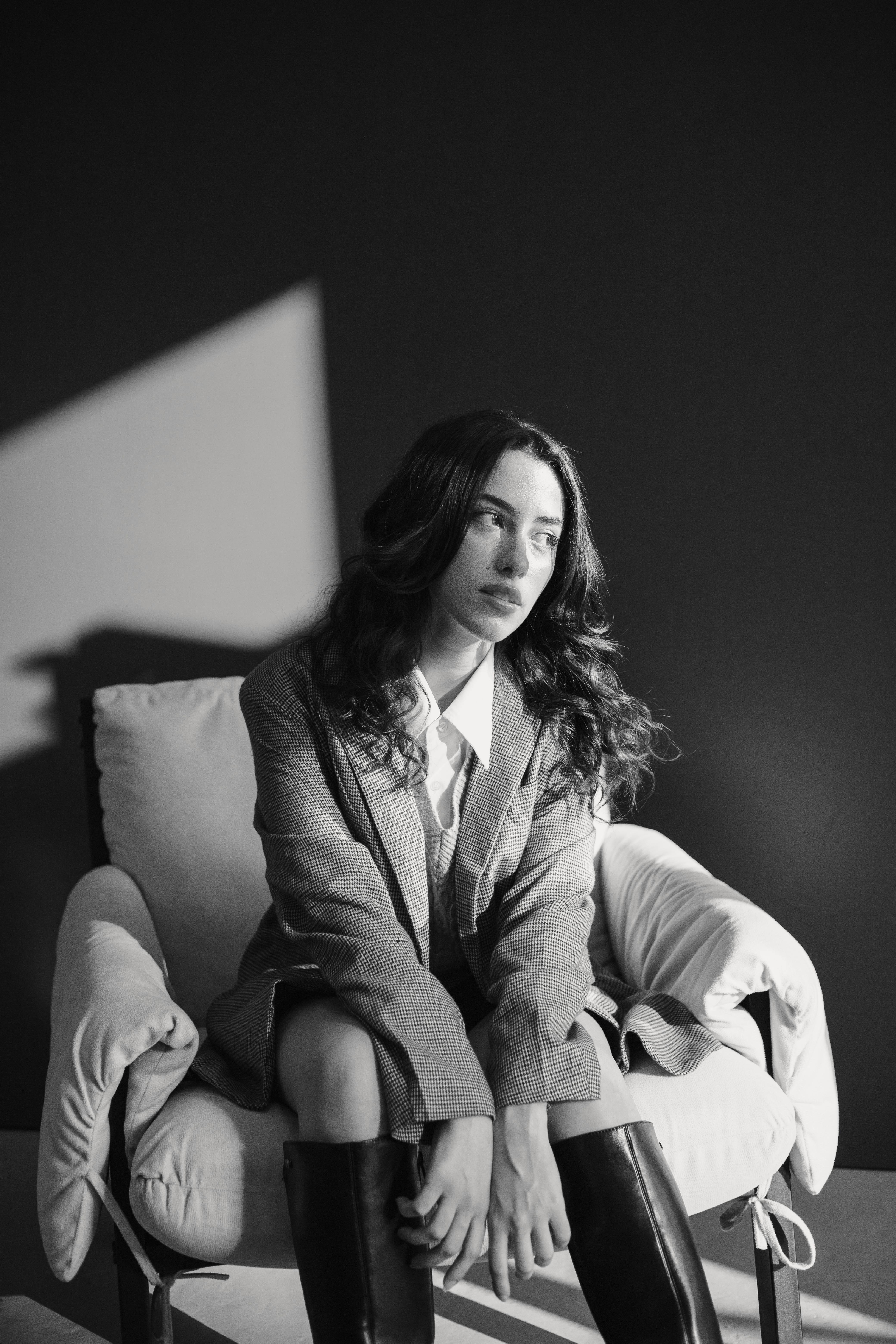 a woman sitting on a chair in black and white