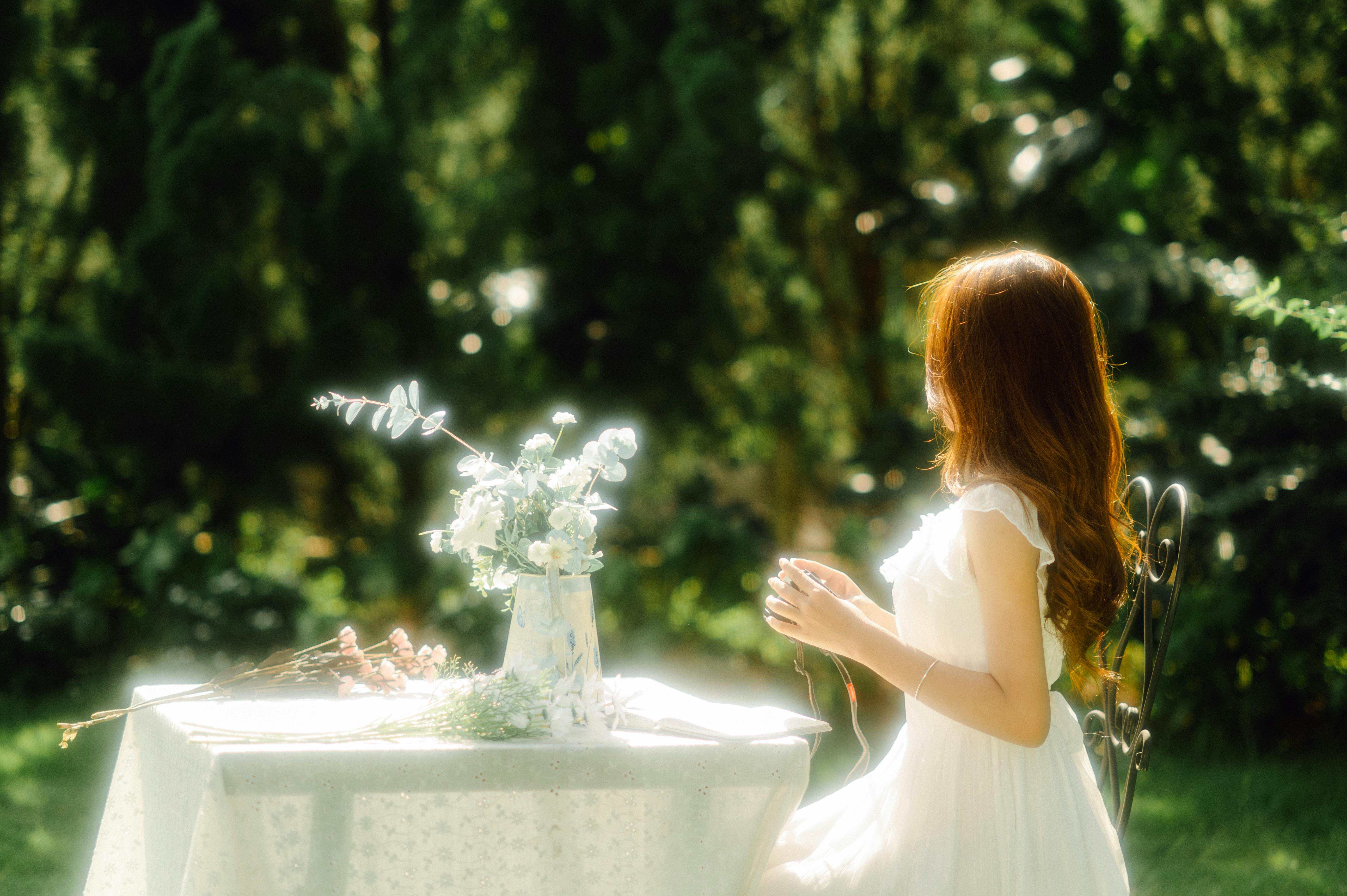 A woman sitting at a table with flowers