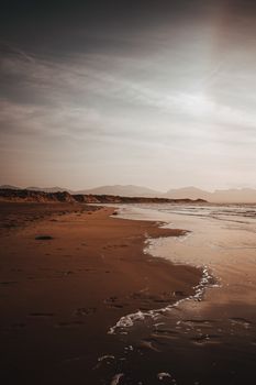 Breathtaking sunset view on a remote beach at Ynys Llanddwyn, showcasing golden sands and tranquil waters.