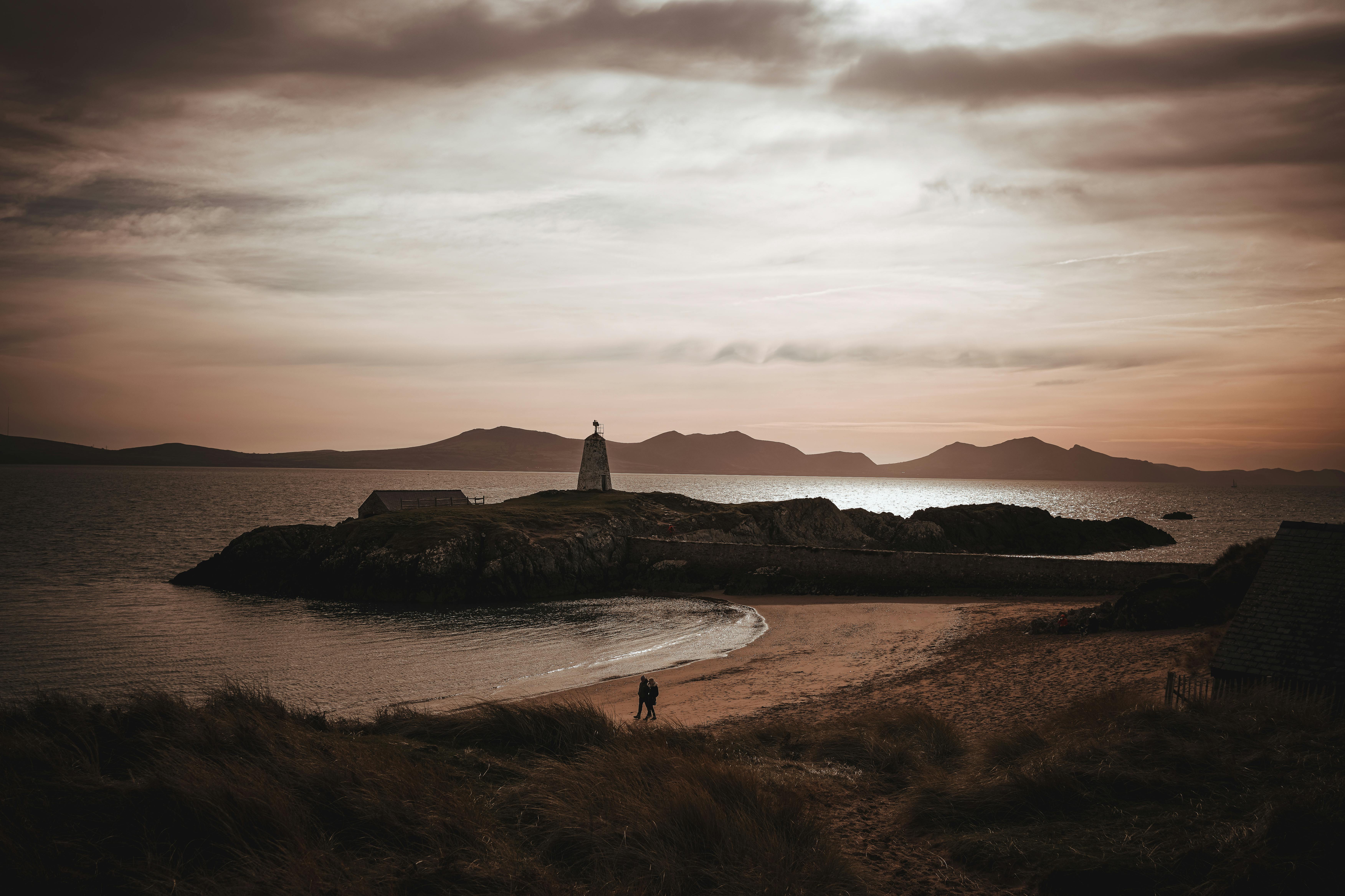 A romantic sunset view of Ynys Llanddwyn with lighthouse and beach, Wales.