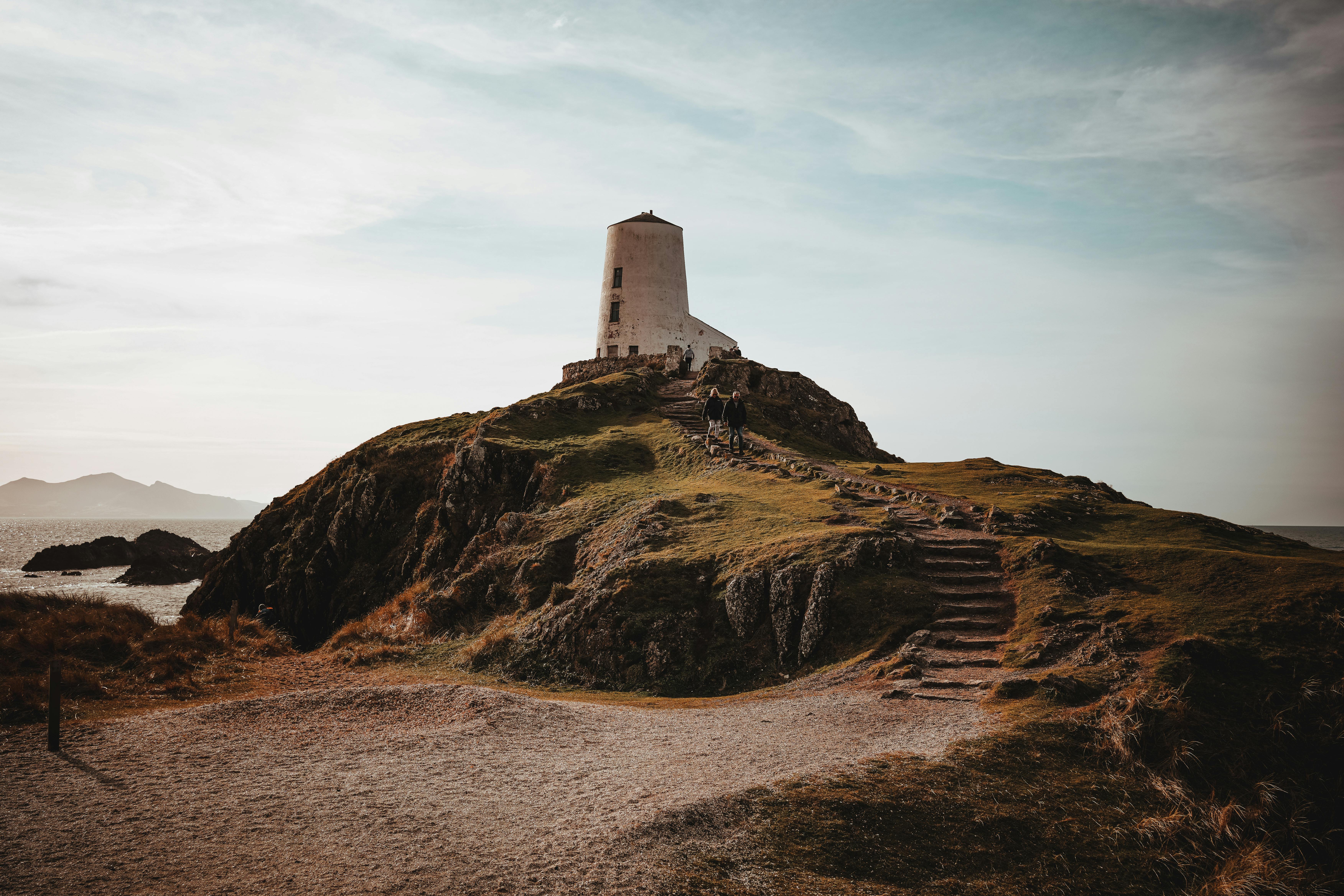 Explore the scenic beauty of Llanddwyn Island with its iconic lighthouse and rugged landscape.
