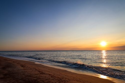 Free Experience the tranquility of sunrise at Sconset Beach, Nantucket with gentle waves and warm hues. Stock Photo
