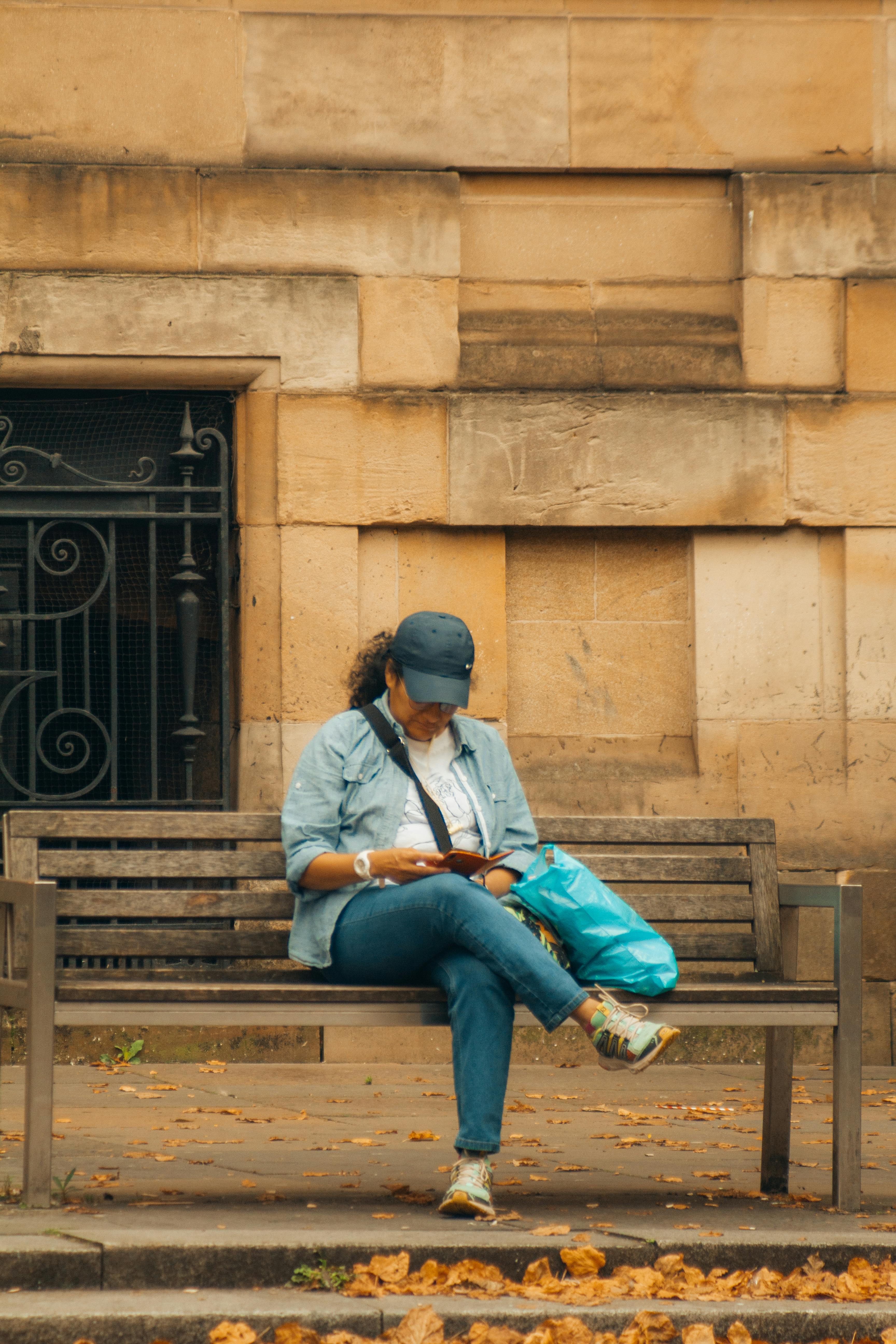 a woman sitting on a bench reading a book