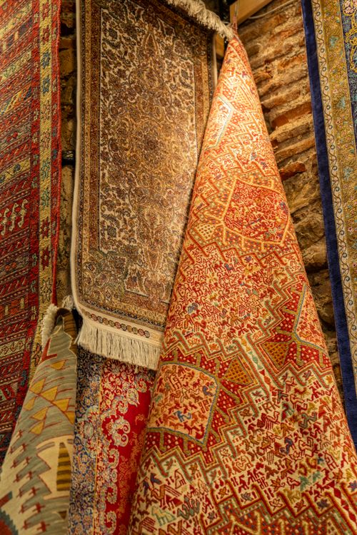 Free A vibrant display of traditional rugs in a colorful bazaar, showcasing intricate patterns and cultural art. Stock Photo