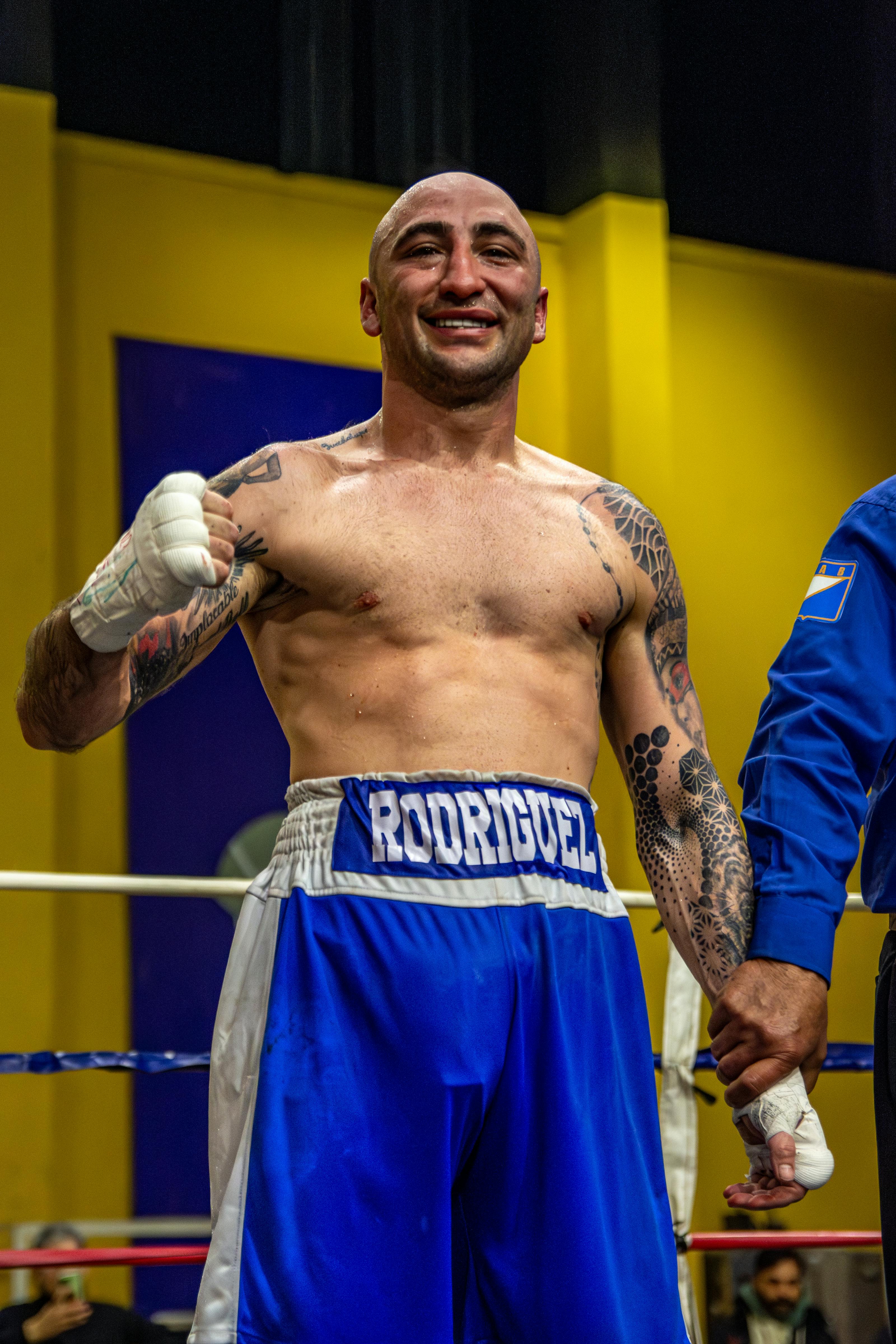 A victorious boxer celebrates his win in the ring, showcasing determination and strength.