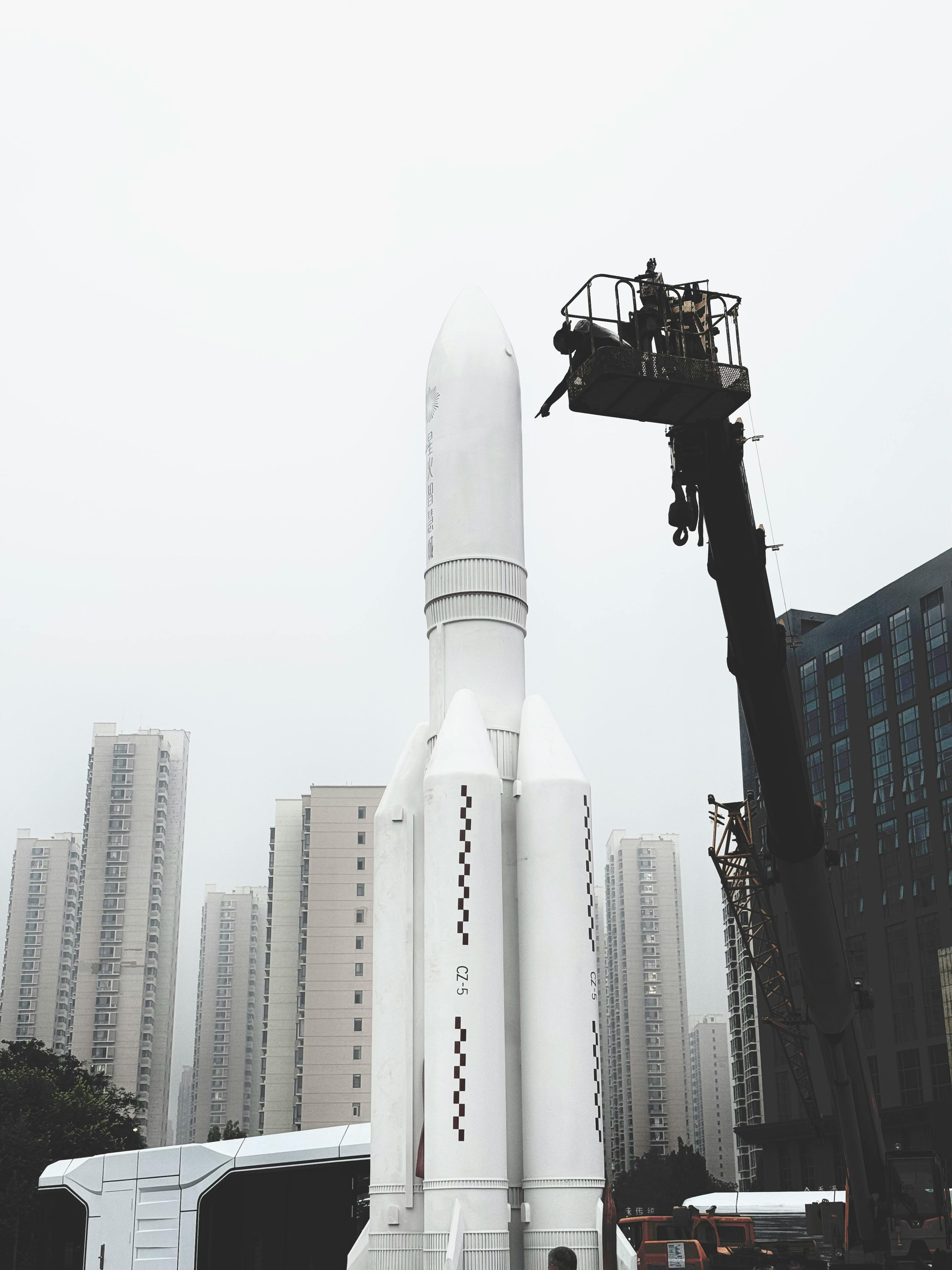 A rocket being assembled in an urban cityscape with tall buildings.