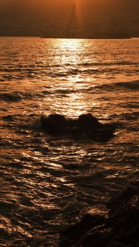 Capture the serene beauty of the ocean at sunset with golden reflections on gentle waves.