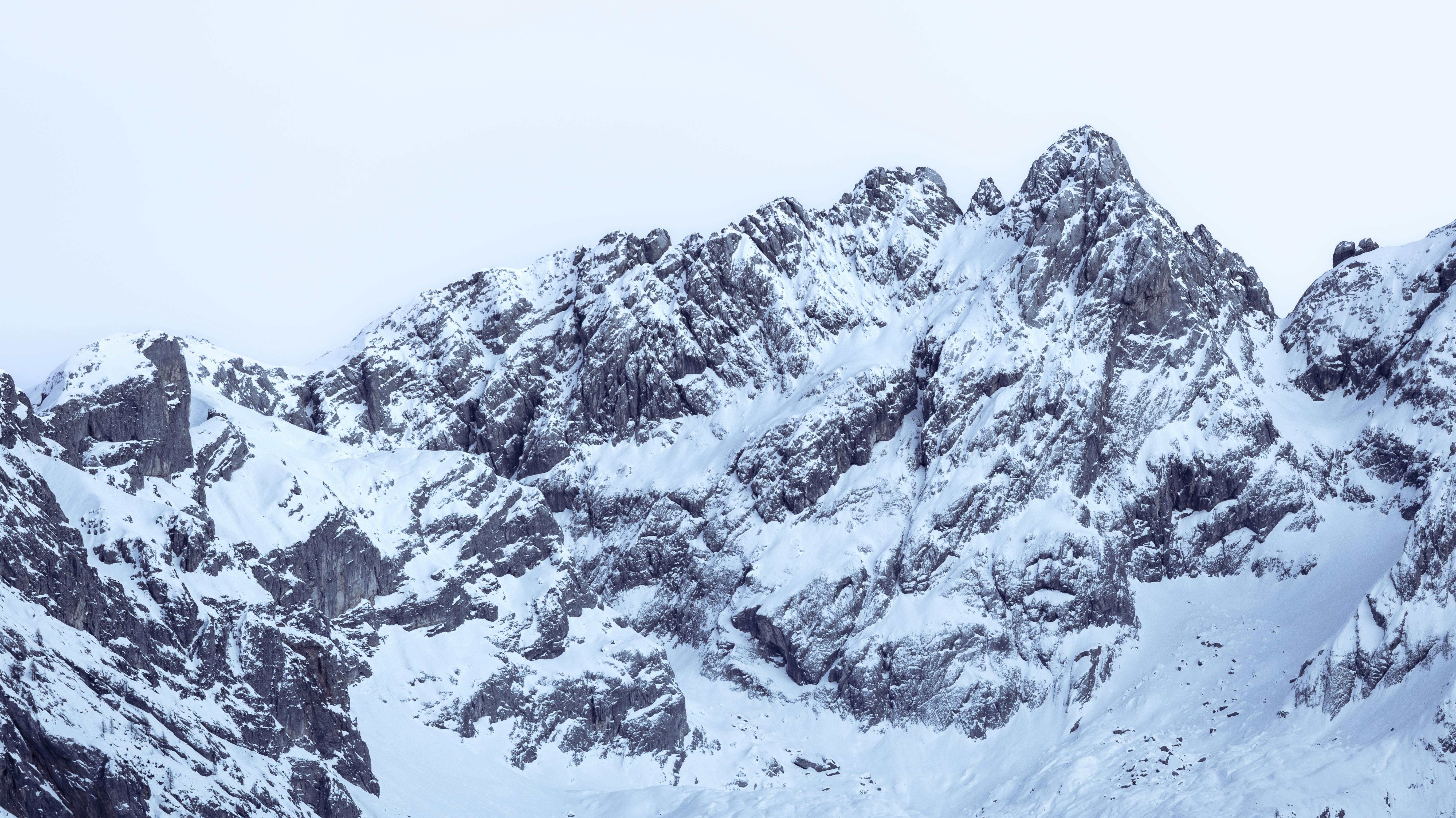 A breathtaking view of snow-covered mountain peaks under a clear winter sky, perfect for nature enthusiasts.