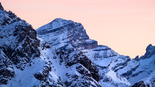 Breathtaking view of snow-covered mountains at sunrise in the Dolomites.