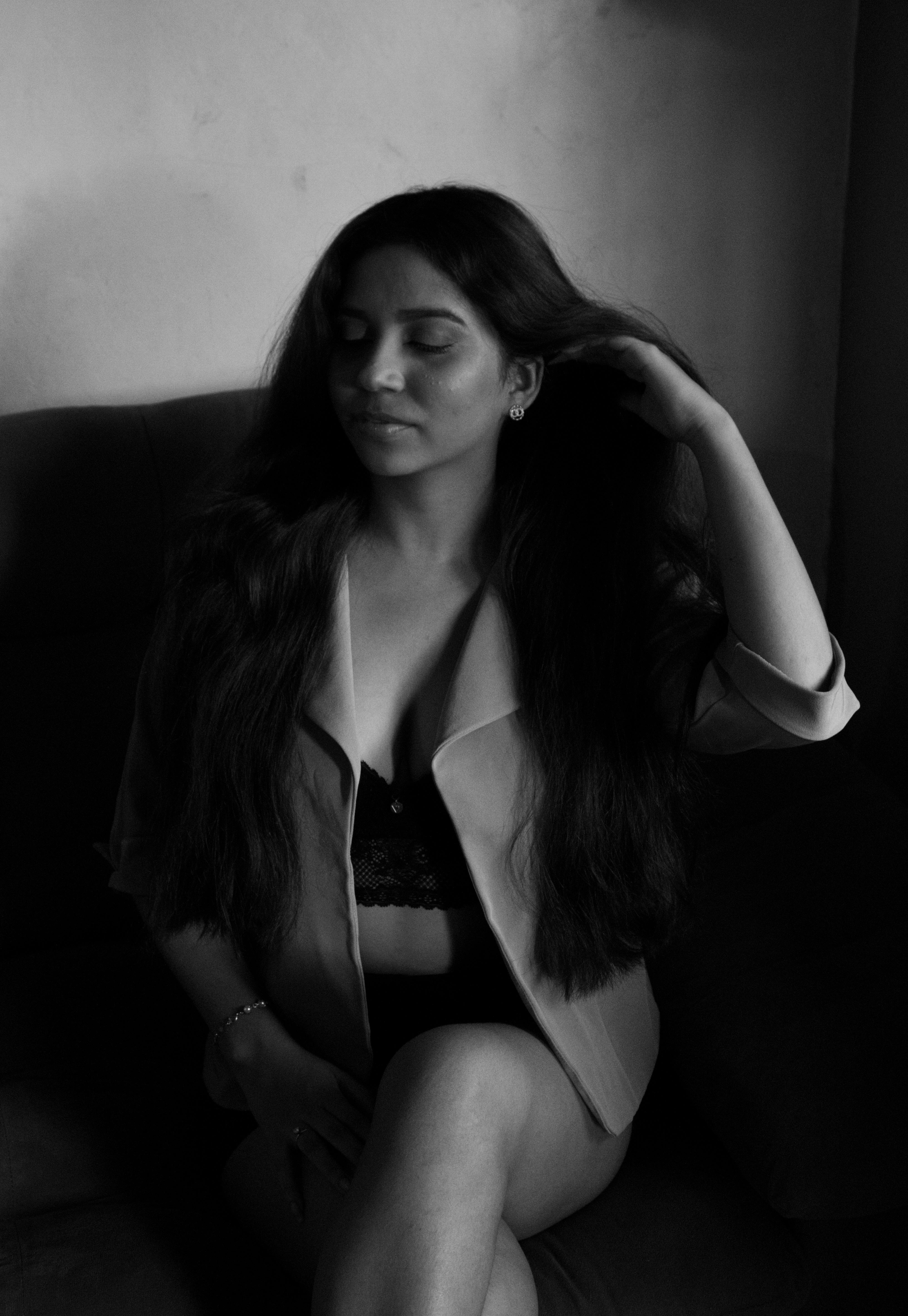 a woman in a black and white photo sitting on a couch