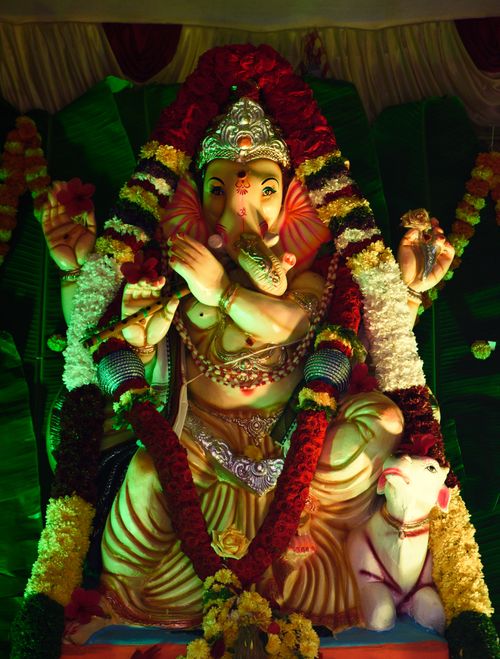 Free Colorful Ganesh idol adorned with flowers, symbolizing Indian culture and spirituality. Stock Photo